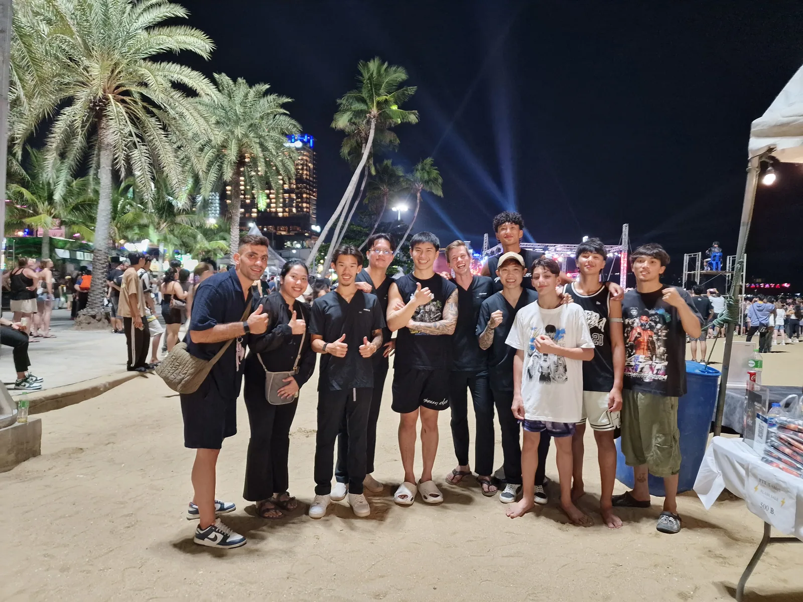 R&P team members and event participants posing together at an evening beach event.