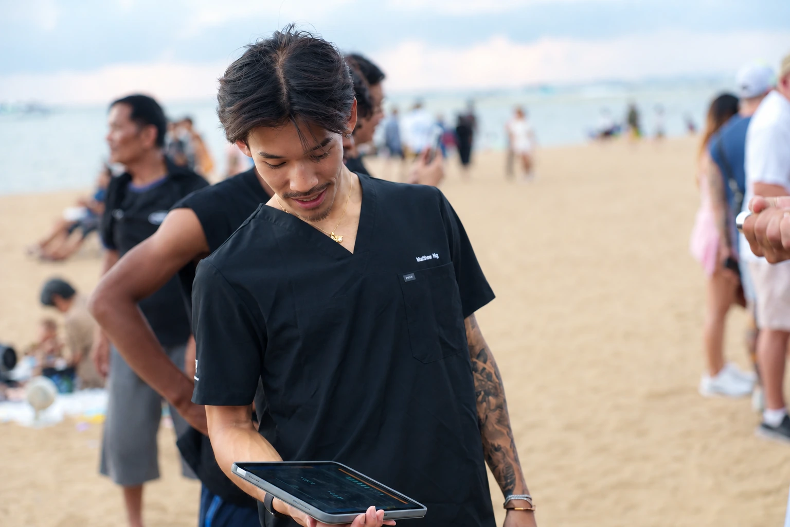 โค้ชดูข้อมูลบนแท็บเล็ตในงาน King of Fight ริมชายหาด