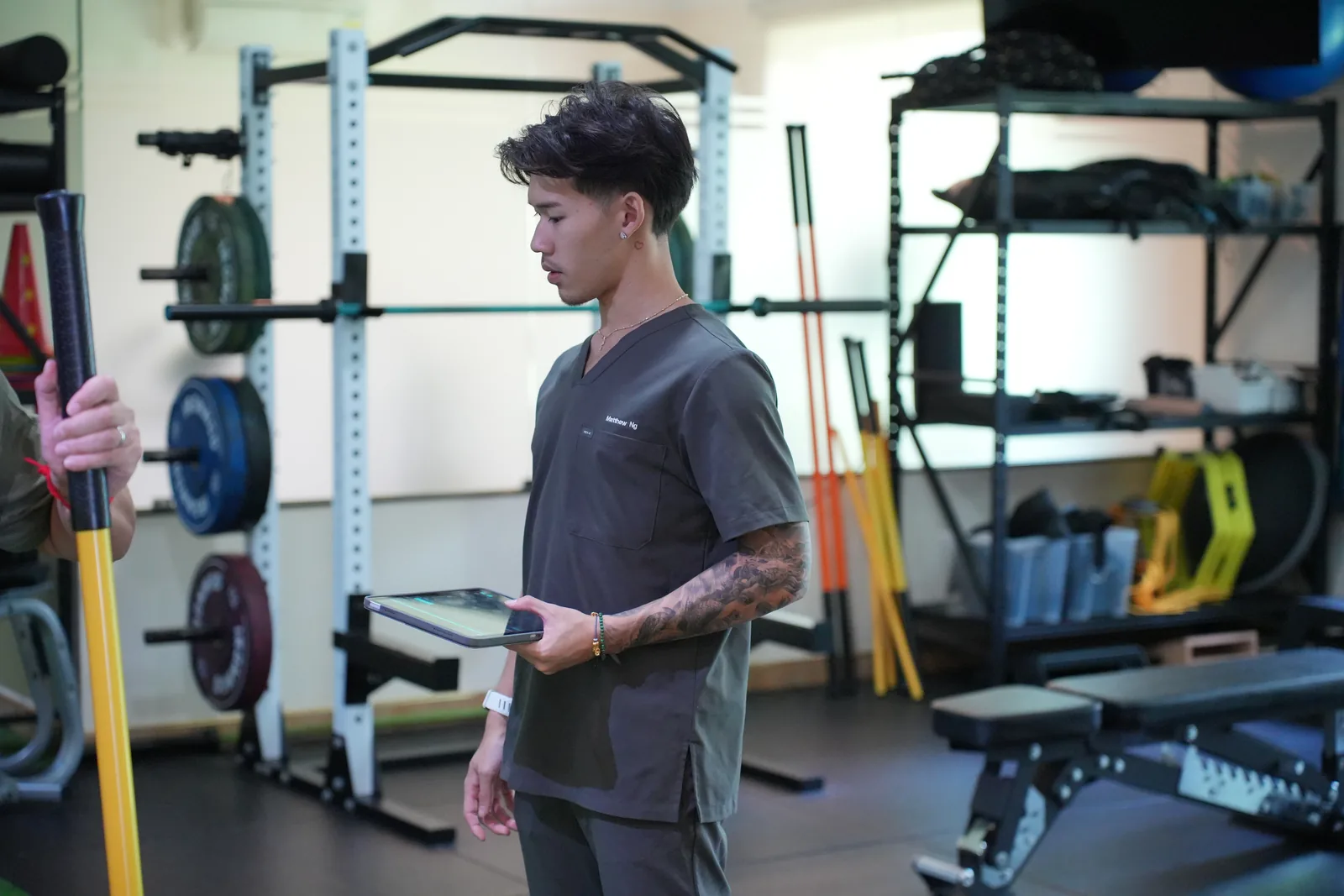 Matthew using a tablet during a coaching session in the gym.
