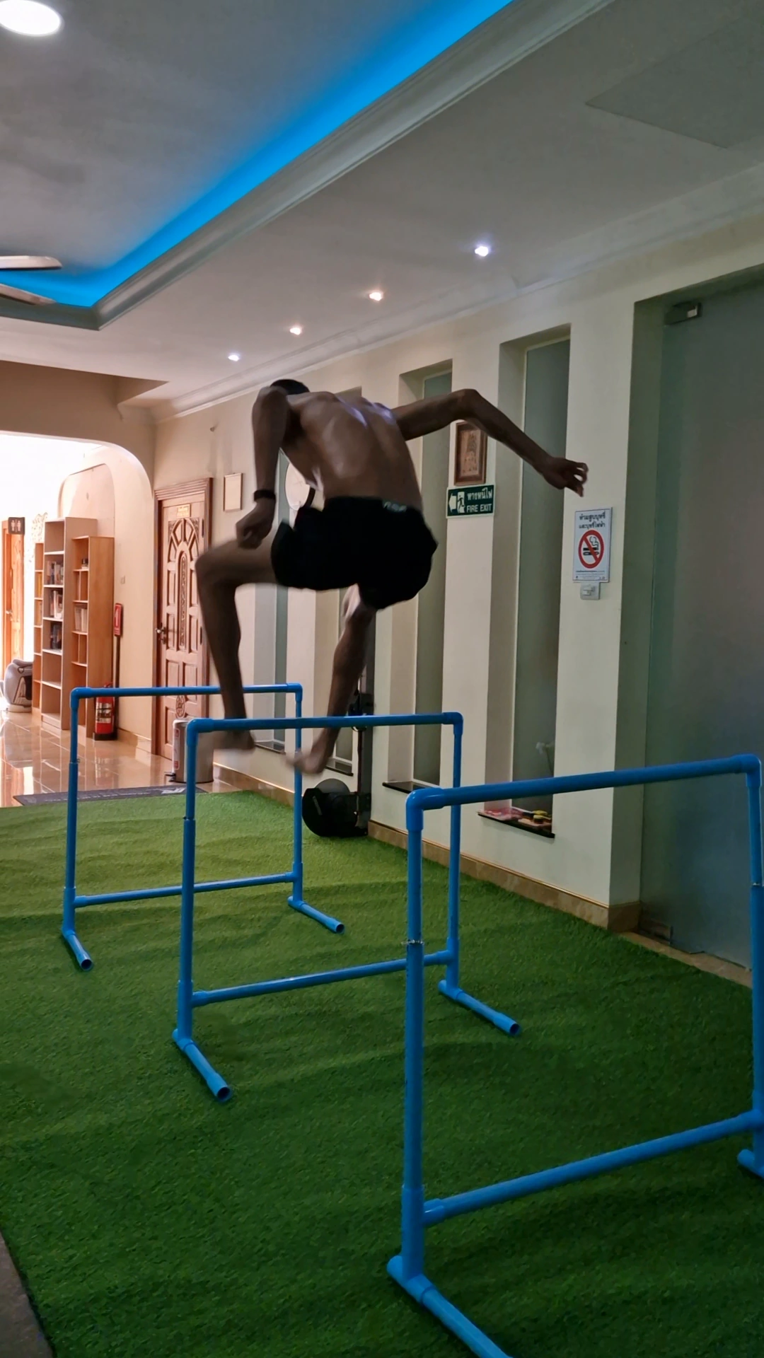 An athlete jumping over a hurdle on the indoor training track.