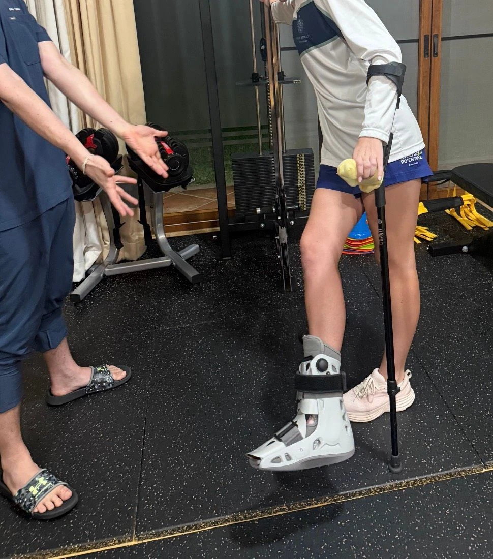 Victoria using crutches and a protective boot during rehabilitation at R&P.